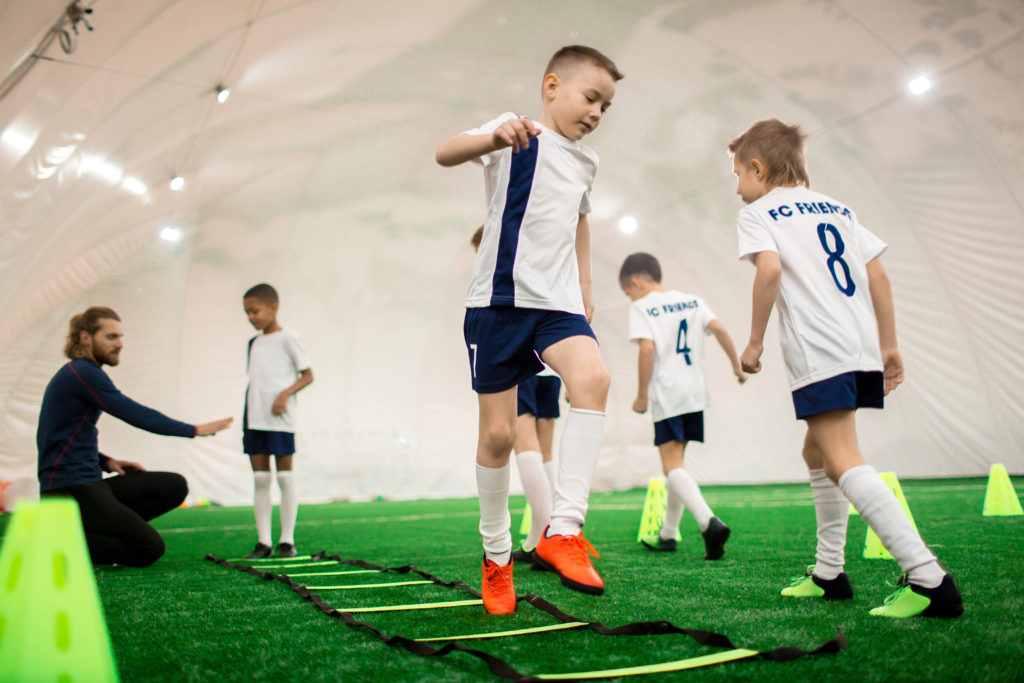 Kids participating in a soccer practice at an indoor sports facility